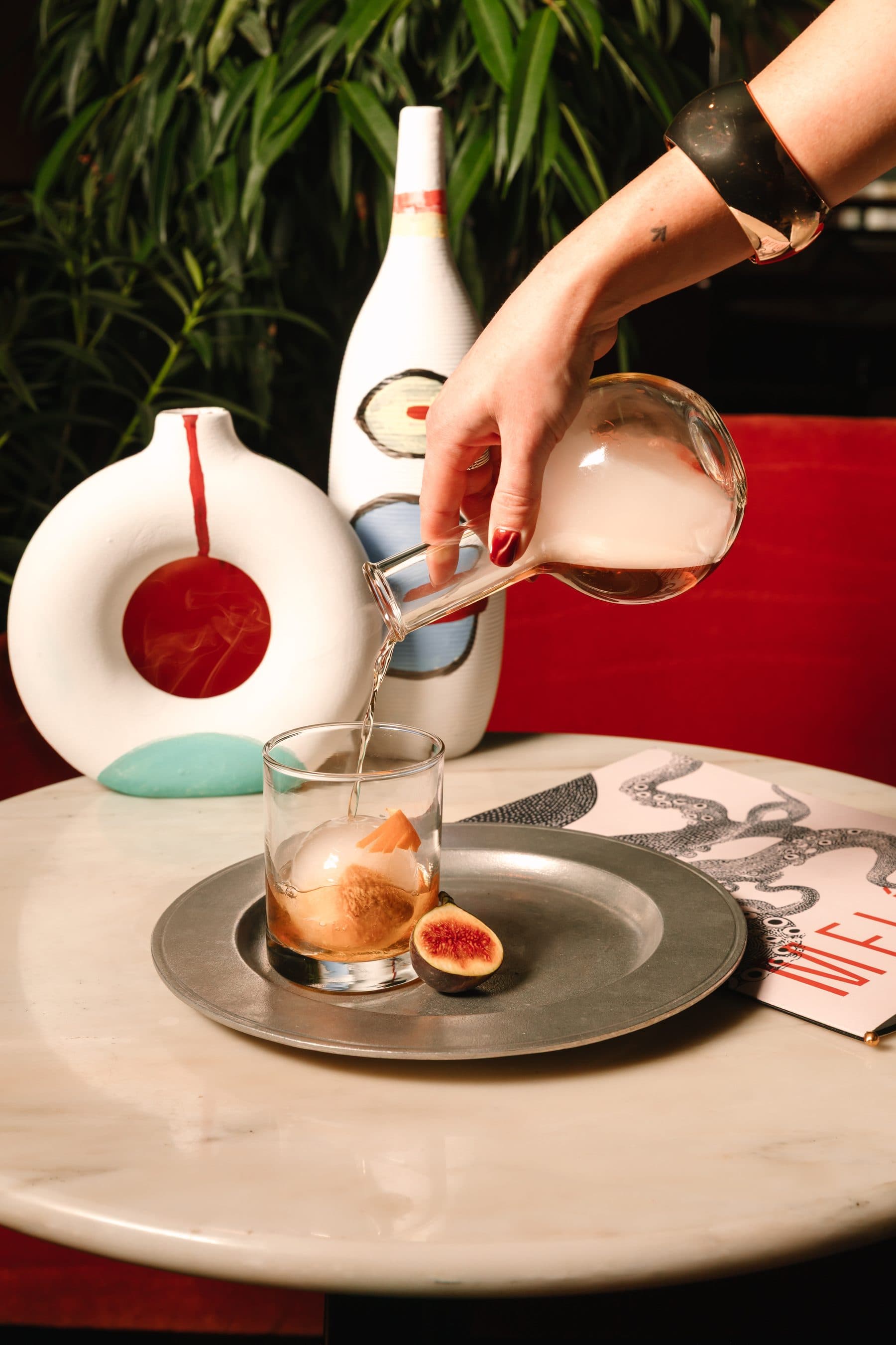 Cocktail poured over fresh figs at the bar