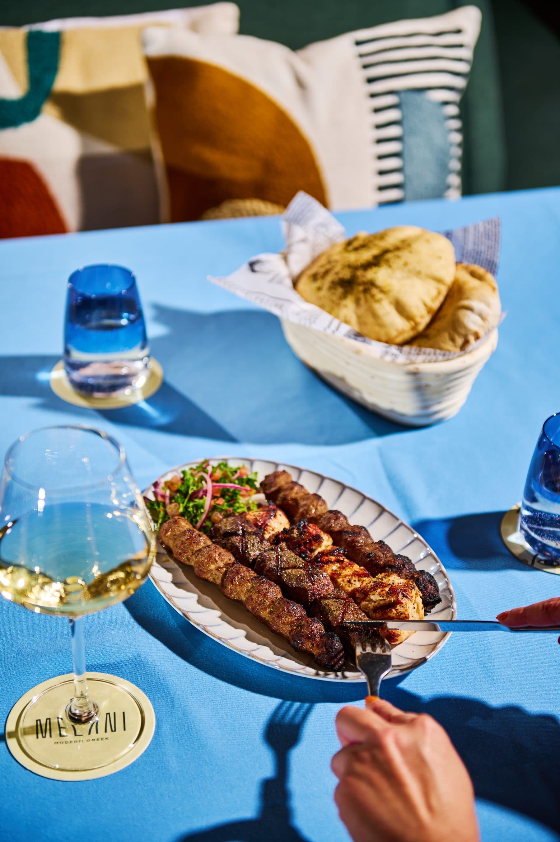 Kofta skewers served with a glass of white wine